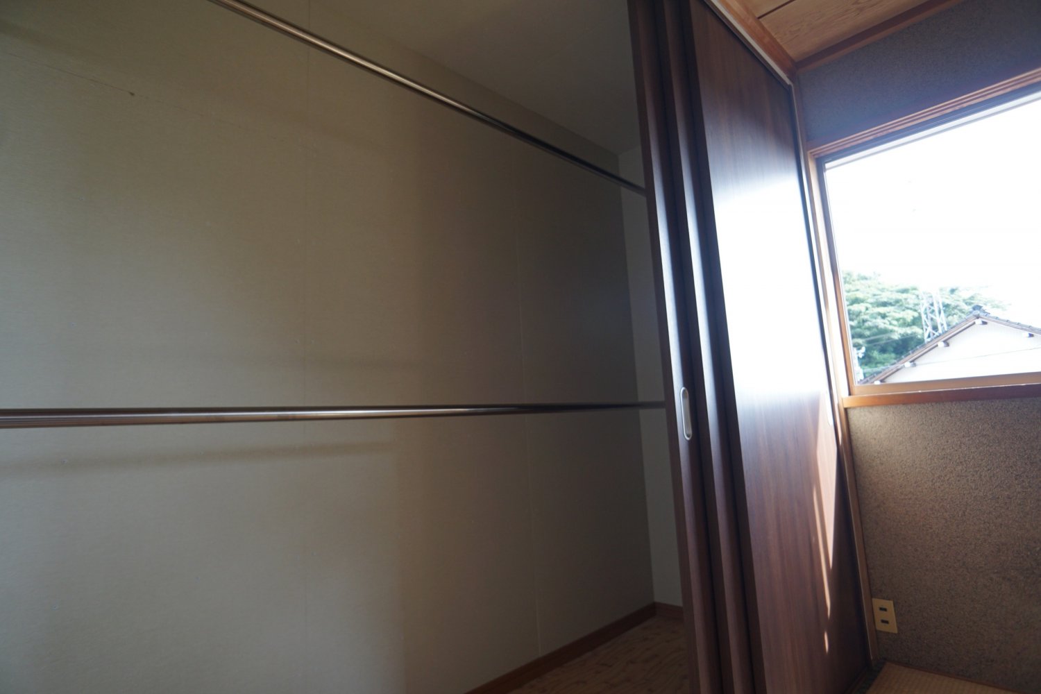 完成後：クローゼットに改修しました。3連動引き戸で大開口が使えます。ステンレスパイプを上下2箇所に設置しました。壁に補強を入れ、幅の広いクローゼットの長いパイプに十分な耐荷重を確保しています。